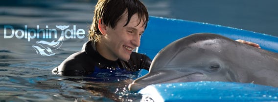 Sawyer and Winter the Dolphin on a mat in the water