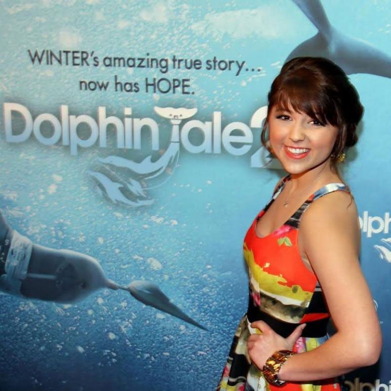 Caroline Kole standing in front of Dolphin Tale poster