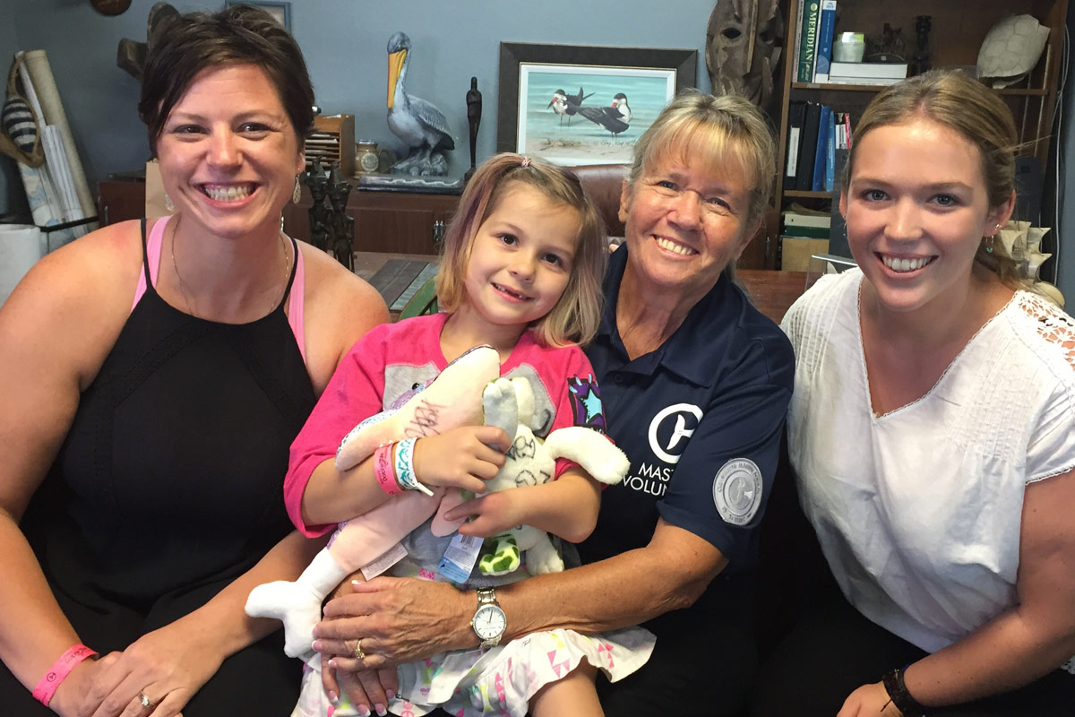 Layla Welch with her mother and inspire team volunteers in Dr. Clay's office