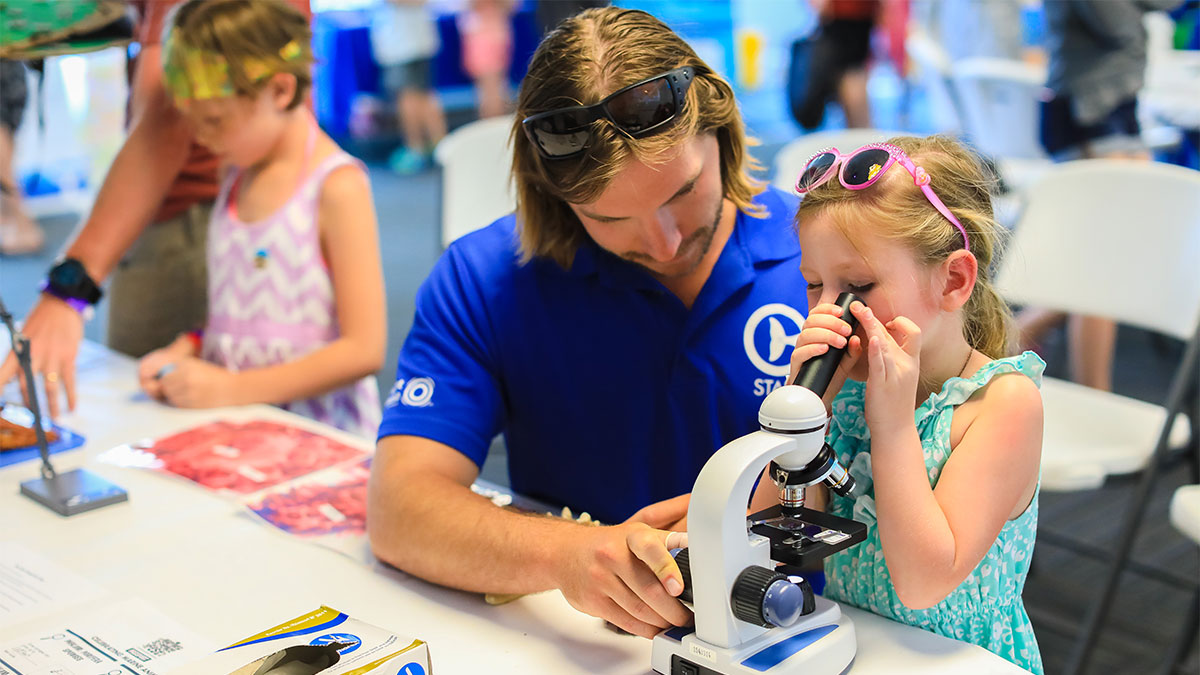 kid looking at microscope